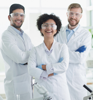 Two man and one woman scientists using laboratory protective equipment and smiling